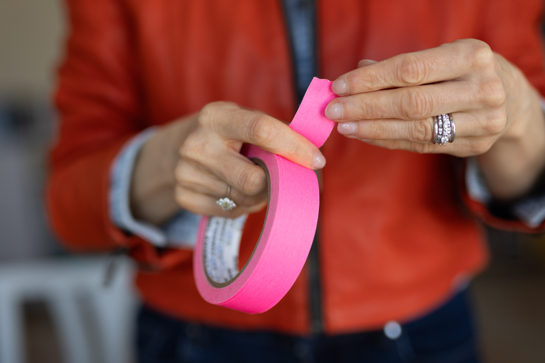 primo piano delle mani di federica tabone che strappano un nastro adesivo rosa